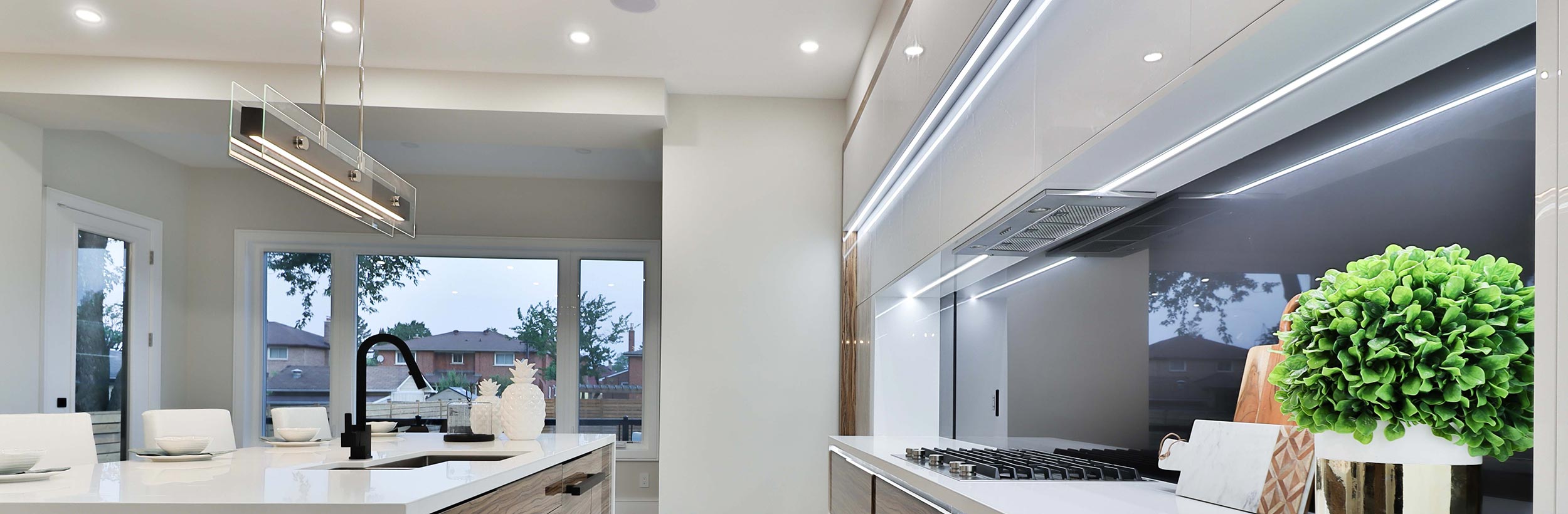 Continuous led strip light glowing underneath the cabinets of a kitchen